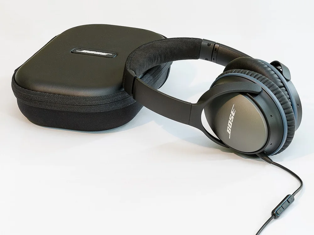 Bose QuietComfort 25 wired headphones and carrying case, illustrating the QuietComfort range